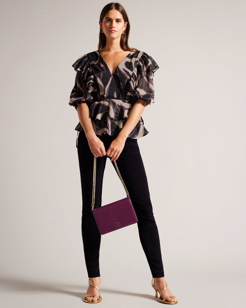 JASMYNA-Tops-Ruffled to perfection and finished with a bow, JASMYNA is your ticket to style heaven. Bottomless brunch? More like your own personal catwalk.The fabric of this product is made of 100% recycled polyester. Using recycled polyester helps divert plastic waste from ending in landfills and helps us to reduce our dependancy on virgin materials. Ruffled top V-neck Abstract print Short sleeved Low back with tie fastening and zip Amy is 5'9.5" / 1.77m and wears Black in a Ted size 1- Ted Baker Romania